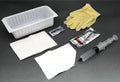 Medical supplies including gloves, syringe, and containers on a dark surface