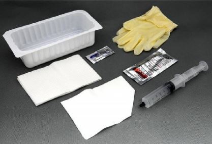 Medical supplies including gloves, syringe, and containers on a dark surface