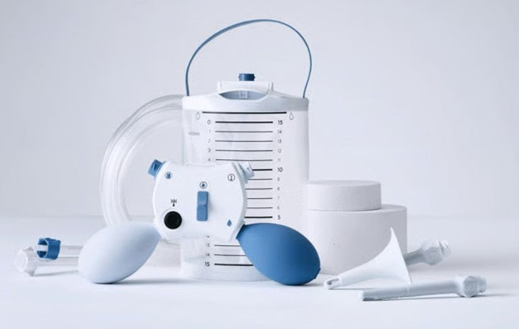 Set of medical equipment including a pump, bottles, and other components on a light gray background